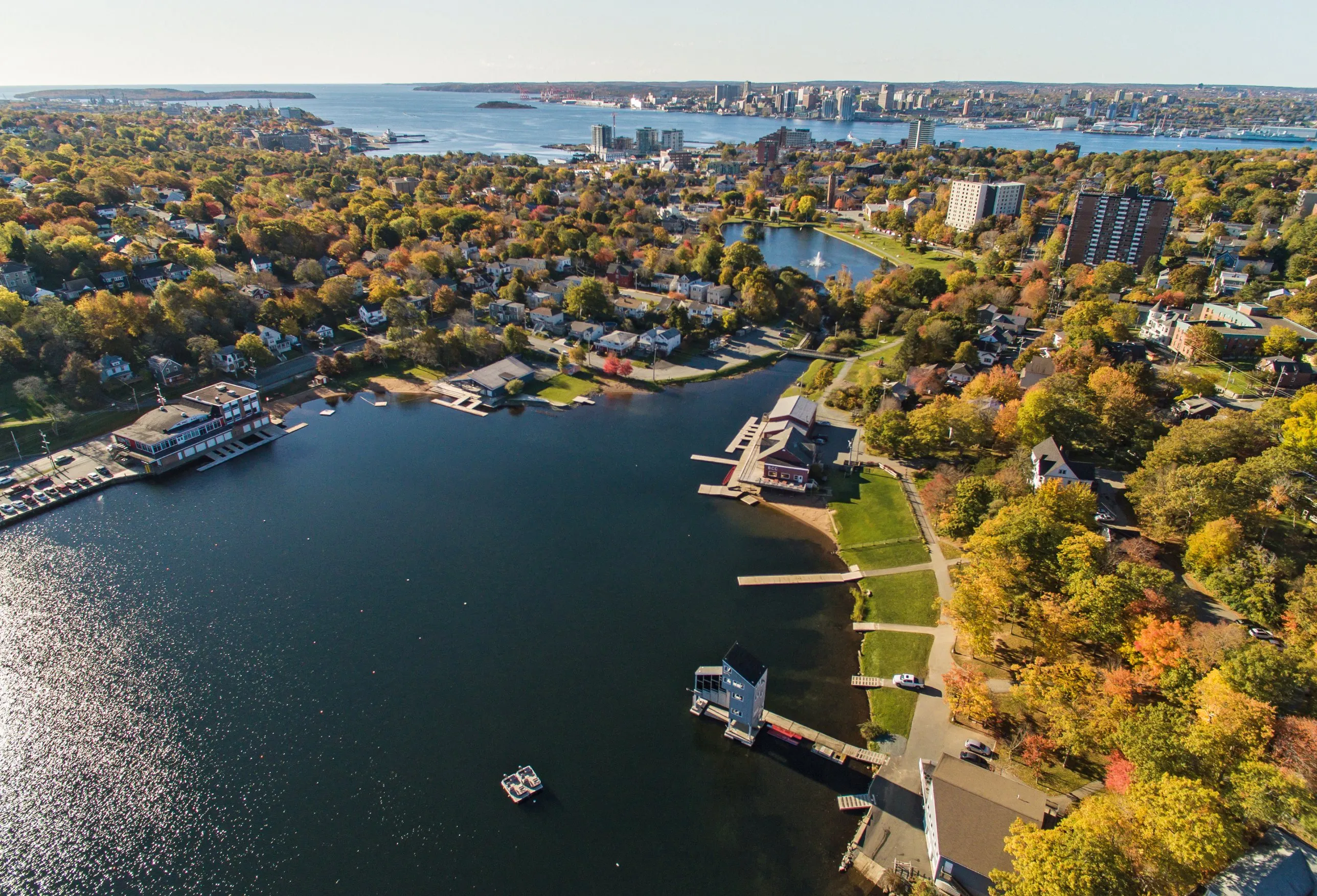 Lake Banook in Dartmouth in autumn, with the Halifax skyline across the harbour behind it